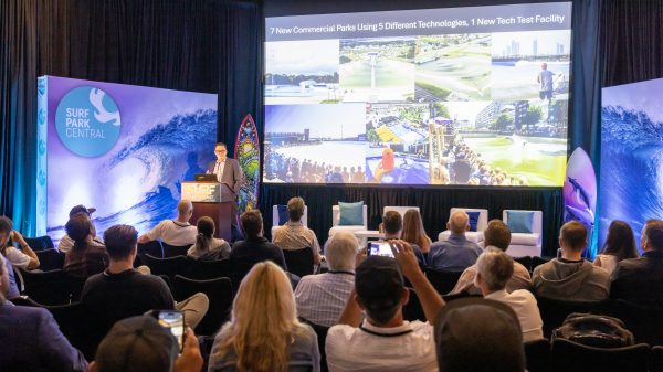 A presentation in front of a large crowd about the surf park industry.