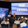 A large room with speakers and "Surf Park Awards" on a screen.