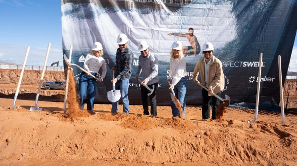 people with shovels dig into red dirt