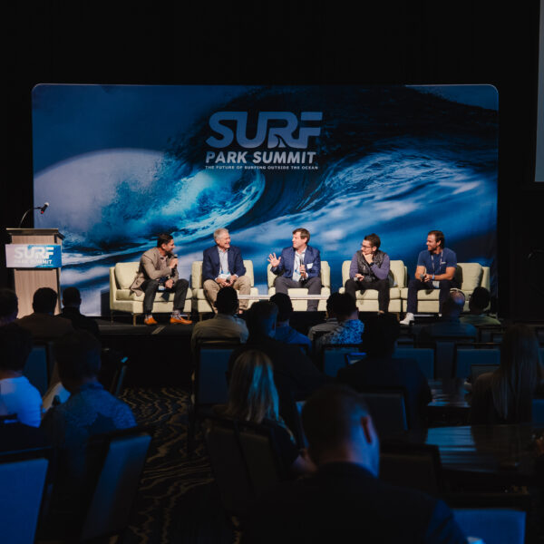 Surf Park Summit panel on stage in front of the logo