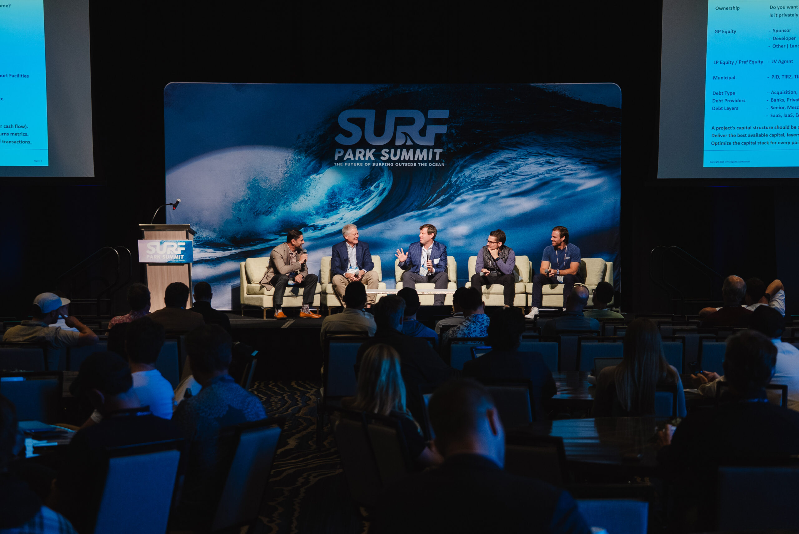 Surf Park Summit panel on stage in front of the logo